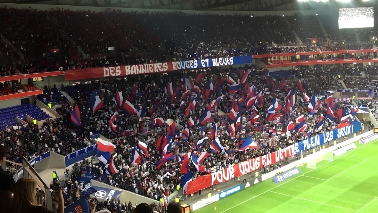 La tribune des ultras lyonnais brandissant des drapeaux français lors d’un match.