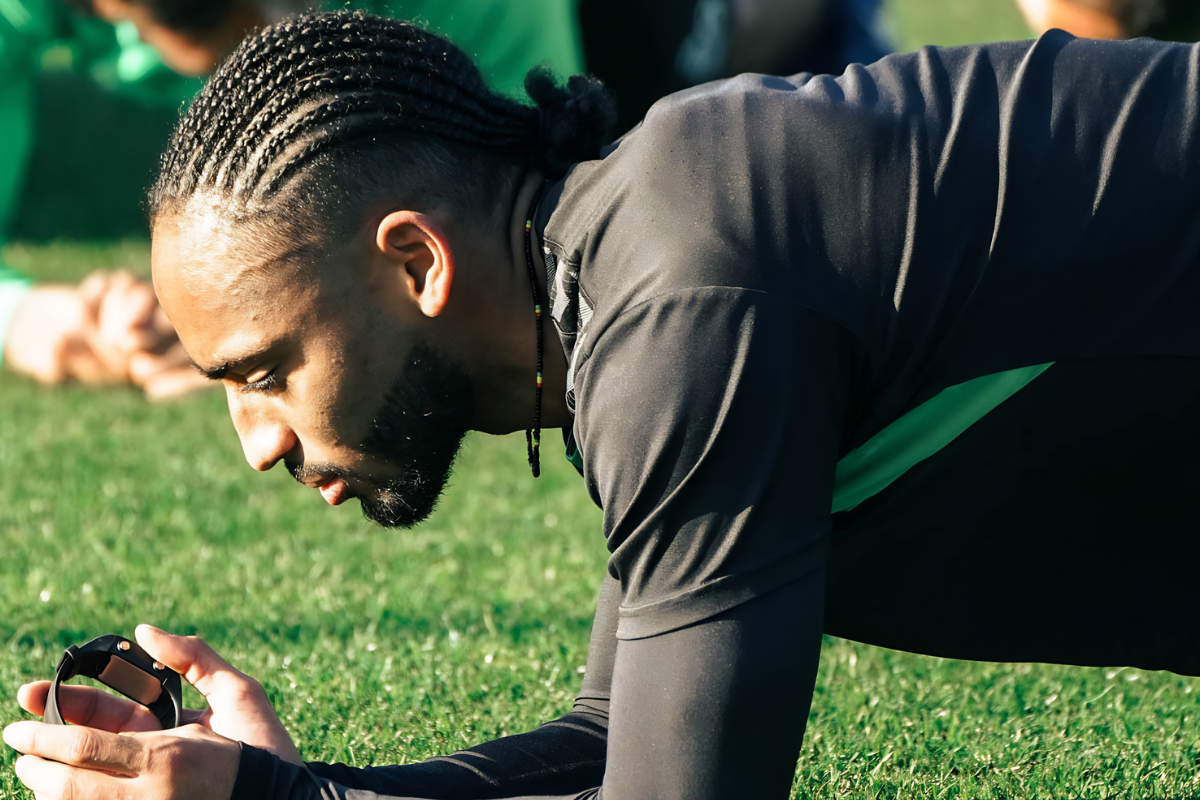 Philippe Djo Petitjean, préparateur physique de l'AS Saint-Étienne,réalise un exercice de gainage lors d'une séance d'entraînement sur la pelouse du Centre sportif Robert-Herbin.